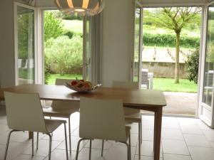 a dining room table with chairs and a bowl of fruit at Les Vignes de Paris in Paris-lʼHôpital