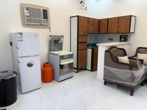 a kitchen with a refrigerator and a chair in it at استراحة العلا in AlUla