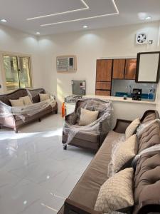 a living room with two couches and a tv at استراحة العلا in AlUla