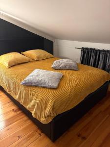Una cama en un dormitorio con dos almohadas encima. en Appartement à proximité d’Epinal avec climatisation, en Dogneville