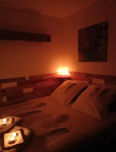 a bedroom with a bed with two candles on it at Du poil à la plume in Saint-Mards-en-Othe