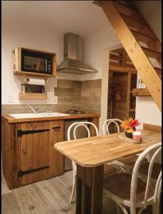 a kitchen with a wooden table and a microwave at Du poil à la plume in Saint-Mards-en-Othe