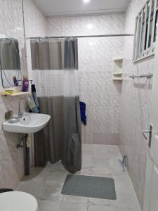 een badkamer met douche en wastafel bij Easygoing in Paramaribo