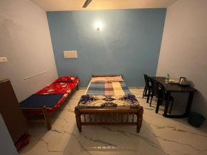 a room with two beds and a table at Olive Homestays in Varkala +2 photos