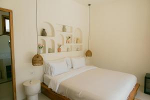a bedroom with a white bed with shelves on the wall at Promo - Private 1BR villa for couples in Kuta Lombok +39 photos