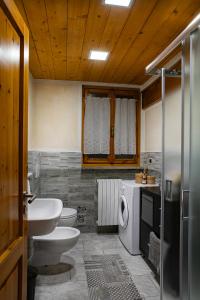 a bathroom with two toilets a sink and a washing machine at Mon grenier in Aosta