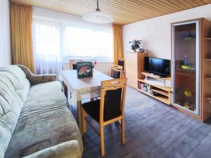 a living room with a table and a couch at Am Springelbach in Hinternah