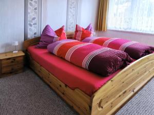 a bedroom with two beds with pink and purple pillows at Am Springelbach in Hinternah
