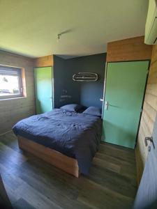 a bedroom with a bed and a green wall at Mechanical cottage, old cars and bikes in Charmes