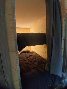 a small room with a bed in a wooden cabin at Mechanical cottage, old cars and bikes in Charmes +5 photos