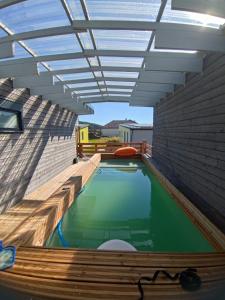 a swimming pool in a building with a roof at Mechanical cottage, old cars and bikes in Charmes