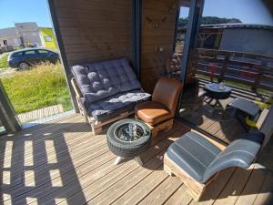 a porch with a couch and a chair and a tire at Mechanical cottage, old cars and bikes in Charmes