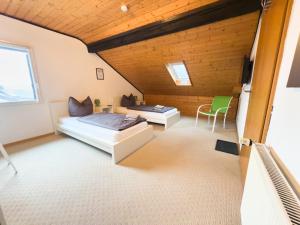 a large room with two beds and a chair at Ringdays Guesthouse in Müllenbach