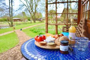 约克Acorn Glade Glamping York的一张桌子,上面放着一盘食物和一瓶葡萄酒