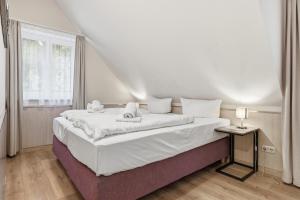 Un dormitorio blanco con una cama con dos toallas encima. en Dünenhäuser Ückeritz UnserUsedomDe FeWo ca50qm mit Parkplatz direkt am Strand 12I3, en Ückeritz