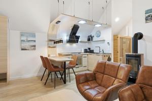 Una cocina y un comedor con mesa y sillas. en Dünenhäuser Ückeritz UnserUsedomDe FeWo ca50qm mit Parkplatz direkt am Strand 12I3, en Ückeritz