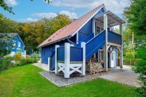 una casa azul con techo rojo en Dünenhäuser Ückeritz UnserUsedomDe FeWo ca50qm mit Parkplatz direkt am Strand 12I3, en Ückeritz