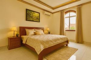 ein Schlafzimmer mit einem großen Bett mit Kassettendecke in der Unterkunft Luxurious River Castle 7 bedrooms in Ho-Chi-Minh-Stadt