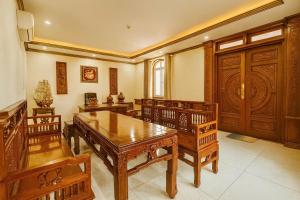 ein Esszimmer mit Holzmöbeln und einer großen Tür in der Unterkunft Luxurious River Castle 7 bedrooms in Ho-Chi-Minh-Stadt + 11 Fotos