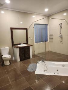 a bathroom with a tub and a toilet and a sink at Bendesa Villa 14 in Ungasan