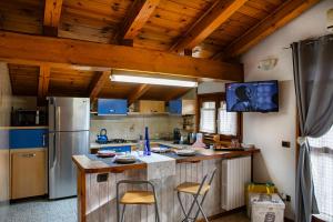 a kitchen with a refrigerator and a counter with chairs at Mon grenier in Aosta +13 photos