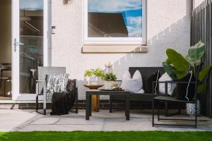 a patio with a bench and a table and chairs at JW Executive ApartHouse 2 in Glasgow