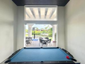 a pool table in a room with a patio at Peaceful Candolim 2BHK Apartment - Family Stay, Scenic View, Pool in Candolim