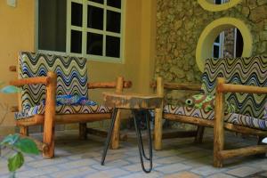 two chairs and a table in front of a building at Arra Fishing Lodge in Adjumani