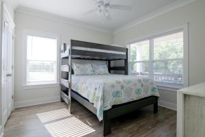 a bedroom with a bed and two windows at Brand New Home with Beach Views! Fully furnished 3 bedroom home in Gulfport in Gulfport