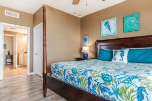 een slaapkamer met een bed met een blauwe sprei bij Spacious Beachview End Unit in Legacy Tower 2 -809 - 3 bedroom 3 bath condo in De Buys +30 foto's