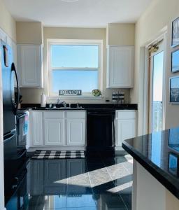 De BuysにあるSpacious Beachview End Unit in Legacy Tower 1 -1001 - 3 bedroom 3 bath condoのキッチン(黒いカウンタートップ付)、窓