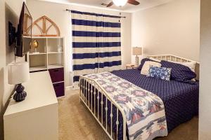 a bedroom with a bed with a blue and white blanket at Waterfront condo at Harbor Landing G02 - Relax in BEAUTIFUL Ocean Springs in Gulf Park Estates +18 photos