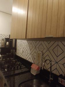 a kitchen with a sink and a stove and a counter top at Paraíso de porto in Porto De Galinhas