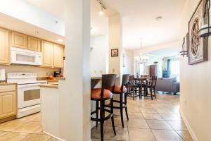 a kitchen and living room with a counter and stools at Beachview Condo at Legacy Tower 2 -706 - fully furnished 2 bedroom 2 bathroom in De Buys