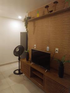 a living room with a flat screen tv on a wooden entertainment center at Paraíso de porto in Porto De Galinhas