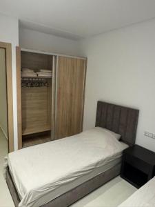 a small bedroom with a bed and a closet at Residence Rmilat Garden Martil in Martil +13 photos