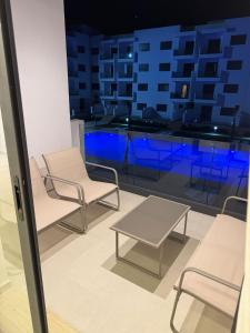 a room with chairs and a table and a window at Residence Rmilat Garden Martil in Martil