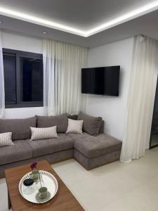 a living room with a couch and a table at Residence Rmilat Garden Martil in Martil