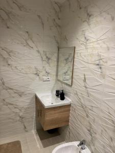 a bathroom with a sink and a mirror at Residence Rmilat Garden Martil in Martil