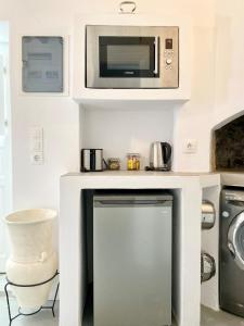 a kitchen with a microwave and a washer and dryer at Cyclops House in Serifos Chora