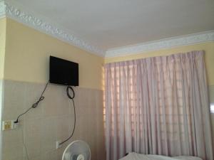 a television on the wall of a bedroom with a bed at 139 Guest House in Phnom Penh