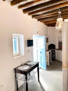 a kitchen with a table and a blue door at Cyclops House in Serifos Chora