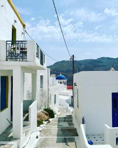 a street with white buildings and mountains in the background at Cyclops House in Serifos Chora