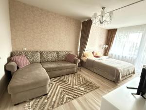 a living room with a couch and a bed at Studio apartment Morkus 2 in Šiauliai