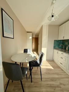 a kitchen with a table and chairs in a room at Studio apartment Morkus 2 in Šiauliai