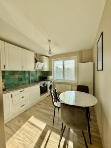 a kitchen with a table and chairs and a refrigerator at Studio apartment Morkus 2 in Šiauliai