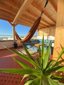 a hammock on a patio with a view of the ocean at KAZA Wave Surf camp in Imsouane