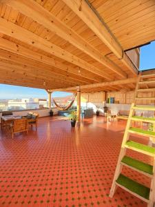 a large room with a wooden ceiling and a staircase at KAZA Wave Surf camp in Imsouane