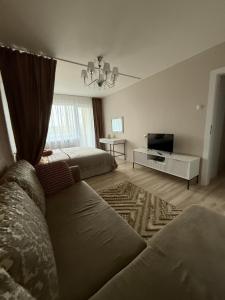 a living room with a couch and a television at Studio apartment Morkus 2 in Šiauliai