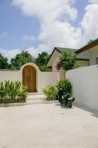 a house with a motorcycle parked in a driveway at Turtle Villa 2 in Kuta Lombok